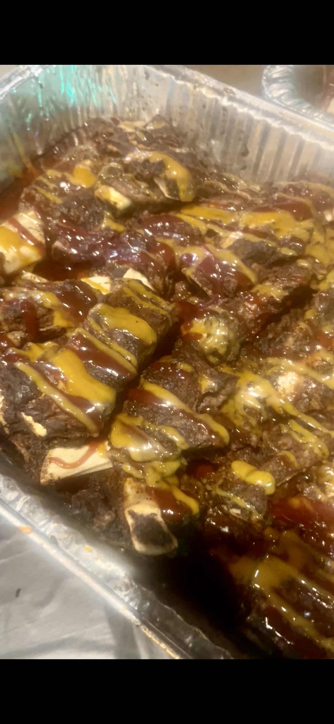 Tray of ribs glazed in BBQ and gold sauce
